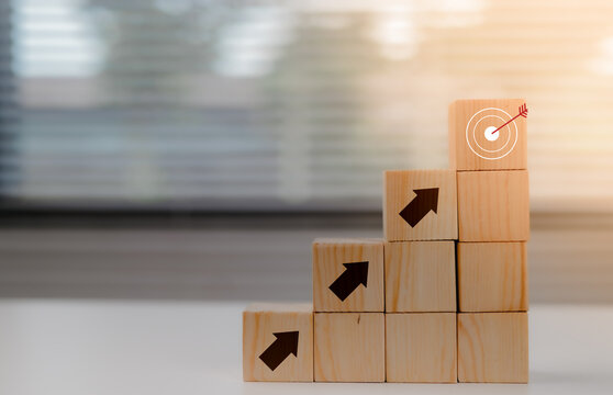Virtual target board and increasing arrow which print screen on wooden cube. Business achievement goal and objective target concept.