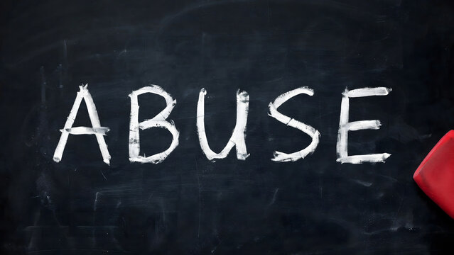 Word abuse written in chalk on a dark blackboard with a red eraser