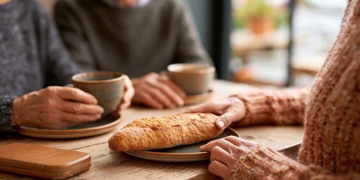 Elderly people sharing bread and coffee
