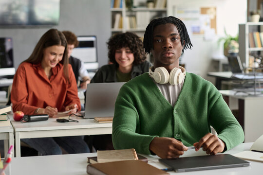 Young man studies in university classroom with diverse classmates