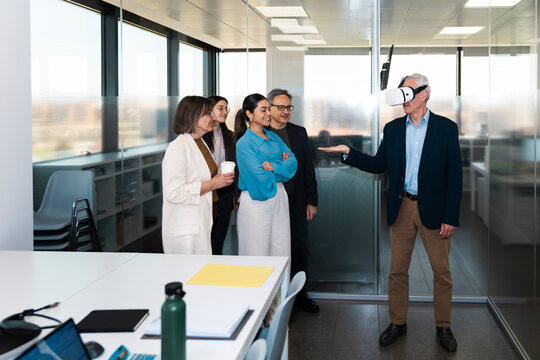 Business team watches a businessman using a virtual reality headset