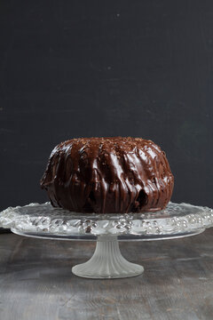 Chocolate cake on glass cake stand, close up