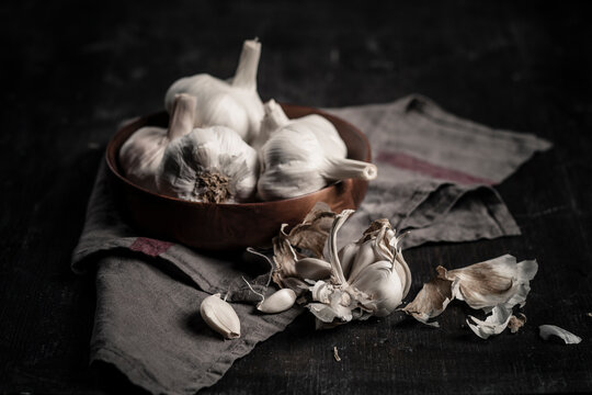 Garlic cloves and bulbs against dark background
