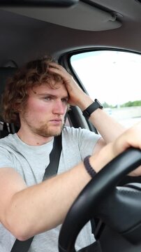 Vertical screen weary driver is drained by the long road and struggles with rising travel fatigue while continuing the journey through busy traffic and monotonous scenery