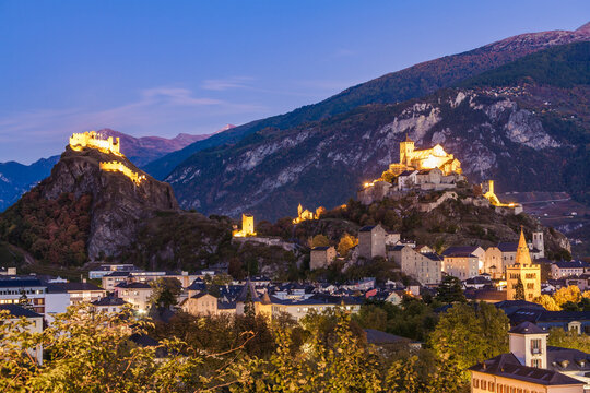 Switzerland, Canton Vaud, Sion, townscape with Tourbillon Castle, Notre-Dame de Valere and Notre Dame du Glarier at dusk