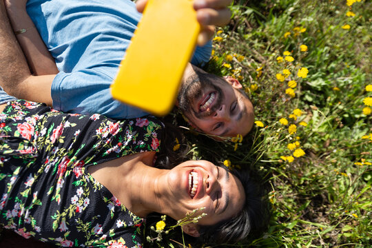 Couple taking a selfie while relaxing in a meadow