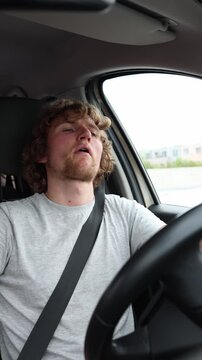 Vertical screen confident driver keeps his head held high and looks cool behind the wheel projecting pride status and personal charisma while cruising along an urban road
