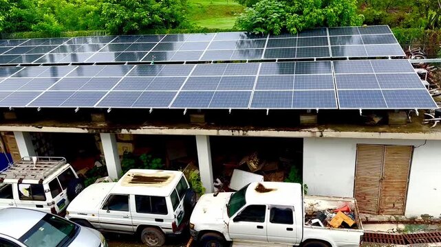 Modern solar panels installed on rooftop of rural car garage