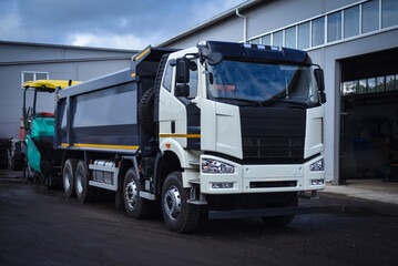 Heavy dump truck parked at a vehicle base. Commercial construction transport ready for work, hauling bulk materials, and operating on construction and industrial sites. © senssnow