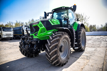 Close-up of a modern stylish green tractor. Detailed view of contemporary agricultural machinery highlighting its design, powerful construction, and advanced engineering. © senssnow