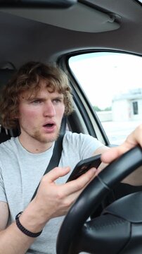 Vertical screen distracted driver looks at a smartphone then brakes suddenly and stops just in time narrowly avoiding a very serious traffic accident on a busy urban road