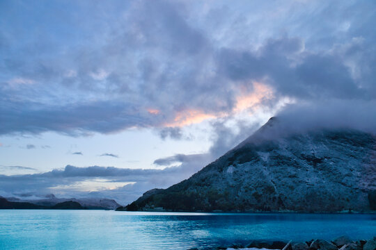 Dramatic clouds over mountains and fjord at twilight