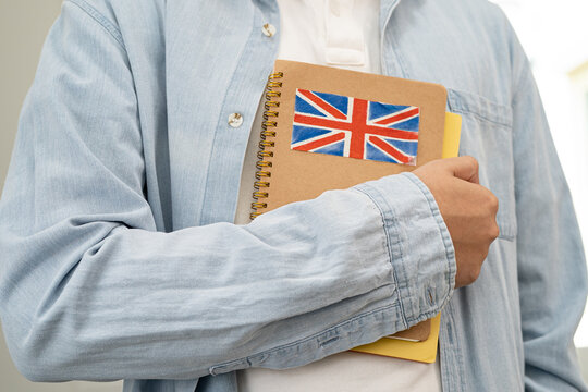 Learn English language, Asian teenage student hold book with flag in course at school.