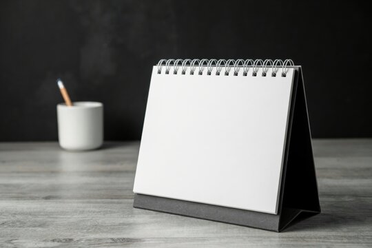 Blank desk calendar mock up on wooden table