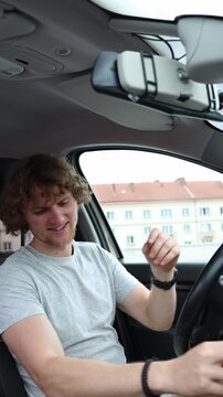 Vertical screen driver sits in a stationary car and refuses to fasten his seat belt pushing the strap away and ignoring standard safety rules before beginning the journey
