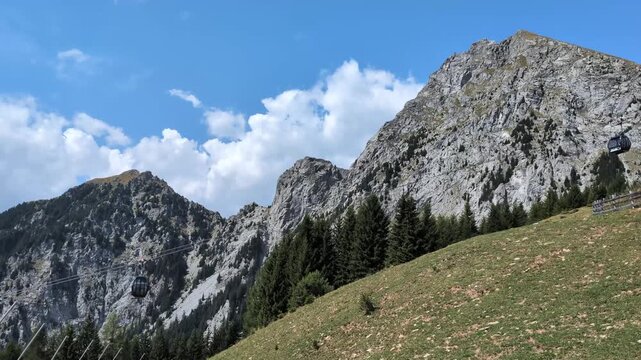 Scenic Cable Car Gondola Ascending Rugged Alpine Mountain Peak Under Blue Sky
