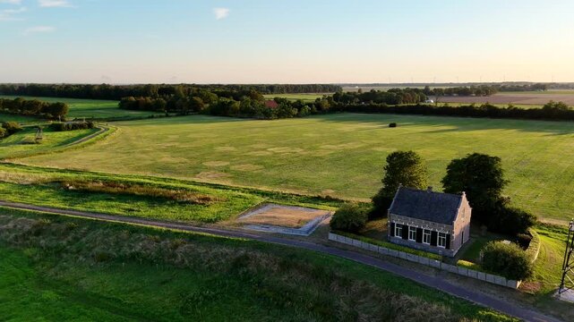 A scenic drone shot capturing the historic former island of Schokland in the Netherlands on a bright, sunny day. rotating show revealing lighthouse.