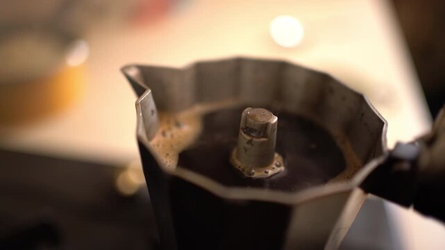 A close-up shows coffee brewing and bubbling inside an Italian stovetop coffee pot, Extreme Close-Up Shot