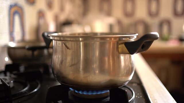 A steaming pot of tomato paste simmers on the stove as a hand enters to add salt, Static Shot