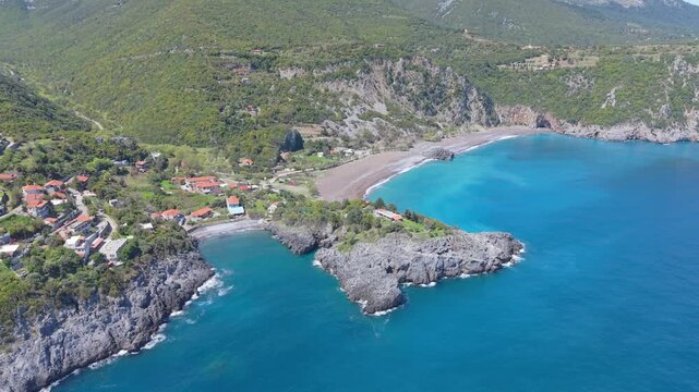 Cinematic aerial footage showcasing Limnionas' rugged shoreline, lush vegetation, and dramatic green mountains in the background, creating a vibrant Mediterranean landscape.