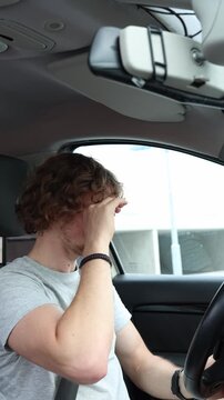 Vertical screen driver rubs his sore and tired eyes while traveling through the city after prolonged focus on the road showing eye strain discomfort and reduced attention