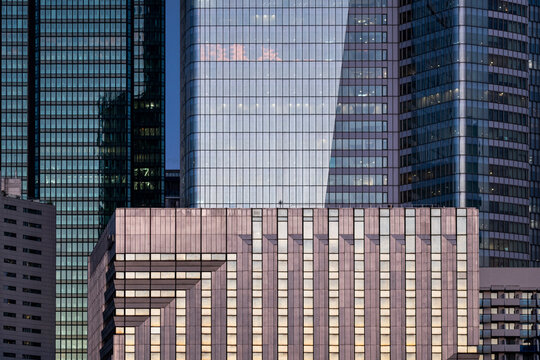 Modern architecture cityscape where glass towers and windows overlap in dense urban geometry with facade reflections and a layered building exterior