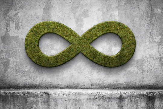 Infinity sign made of fresh green moss mounted on a weathered concrete wall. Circular economy concept for sustainable development presentations.