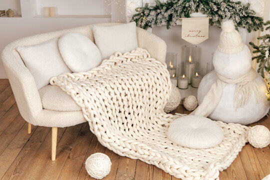 Cozy white decor with soft blanket and snowman in warm indoor setting during winter