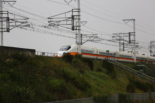 A high speed train runs along an elevated railway track.