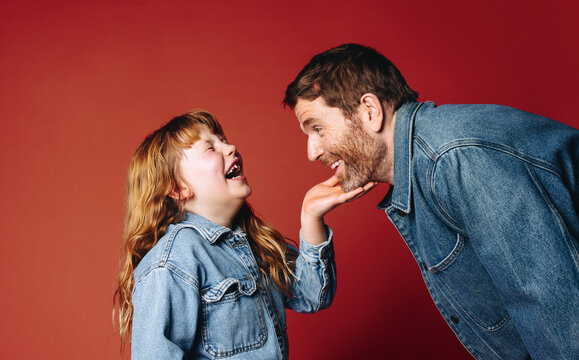 Laughing family joy fills the studio as a father and daughter face each other