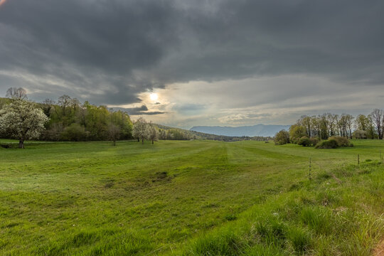 vista panoramica su un'area naturale tra pianura e basse colline nella Slovenia centro-occidentale, di pomeriggio, con cielo nuvoloso, in primavera