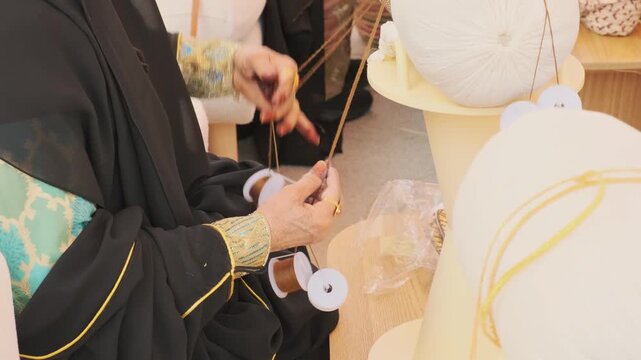 senior woman hand weaves talli craft using kajuja pillow. skilled artisan demonstrates talli craft technique with special ring. traditional talli craft preserves cultural heritage