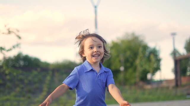 A boy in a blue shirt runs joyfully through the green landscape, smiling as he plays. The boy's excitement is visible in his expressions and movements.