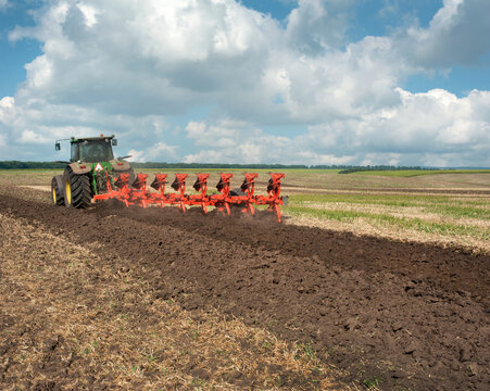 agricultural machinery work, tractor cultivates the land with a plow and a harrow