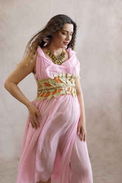 Serene Pregnant Woman in Pink Ancient Greek Toga - Maternity Portrait