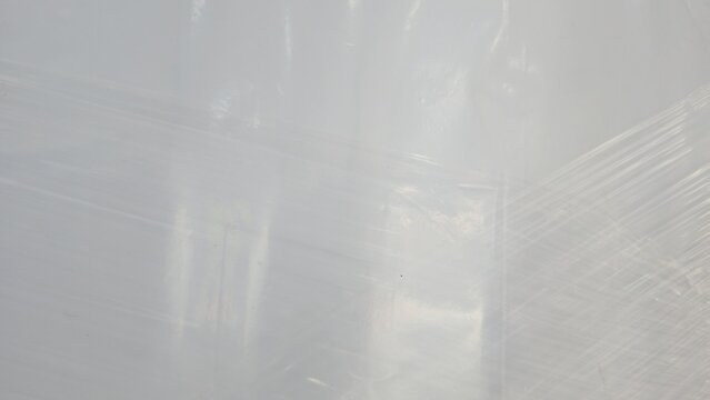 Transparent plastic wrapping film texture for logistics backdrop. Faded commercial plasticized wrap sheets for cargo shielding, displaying fine clean overlay lines.