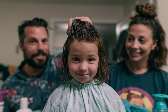 Parents Giving Little Girl Haircut at Home