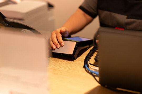 Hotel reception operating a credit card payment terminal at counter