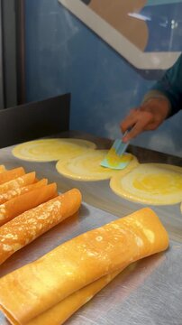 Chef Cooking Traditional Thai Khanom Buang Crepes on Hot Griddle