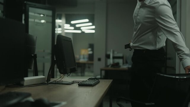 Exhausted Caucasian businessman finishing workday late at night, standing up from desk, grabbing jacket, turning off lights, and finally leaving dark, empty office. Shooting in slow motion.