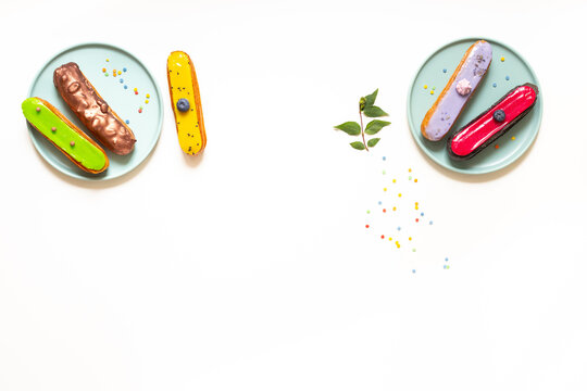 Elegant assortment of glazed eclairs on plates - gourmet pastry presentation with modern cafe aesthetic