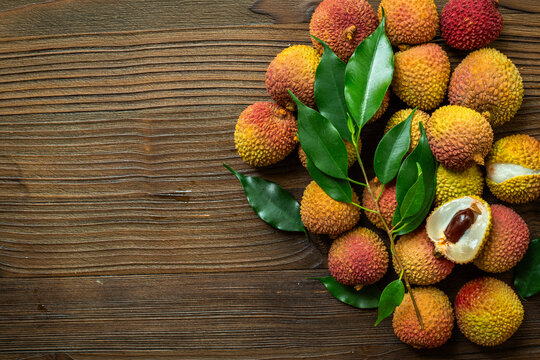 Fresh lychee fruit with green leaves, top view