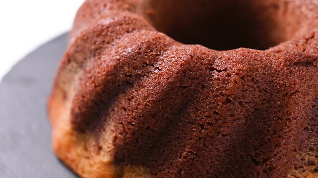Chocolate bundt cake rotating on white background