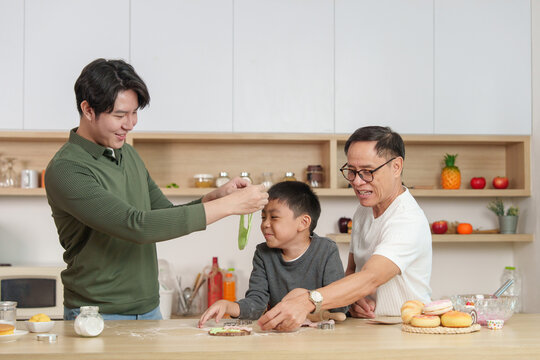 Asian multigenerational family having fun while baking cookies in kitchen