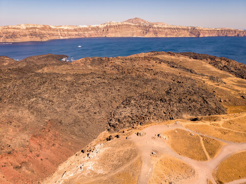 Drone view of Nea Kameni volcanic park crater viewpoint with Santorini cliffside caldera view Greece