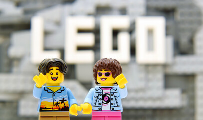 Fototapeta premium Lego minifigures are staying on mountain with word LEGO are builded from white bricks. Editorial illustrative image of popular brand of plastic bricks constructor.