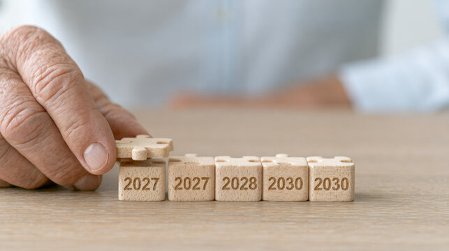Business roadmapfuturistic concept with hand placing wooden blocks marked with years 2027 2028 and 2030 symbolizing business vision planning and future strategy in calm office environment