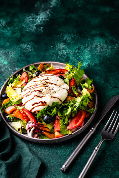 Delicious salad with burrata cheese grilled peaches and blueberry