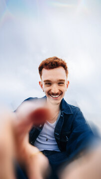 Smiling man taking an outdoor close-up selfie