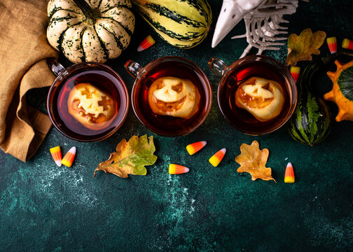 Halloween spicy apple cider with jack-o-lantern faces